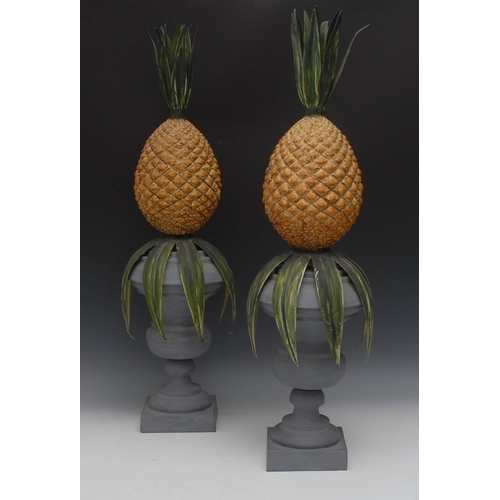 81 - A pair of toleware type campana table urns, each surmounted by a pineapple, square bases, 74cm high,... 