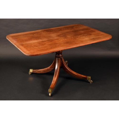 1576 - A Regency mahogany rounded rectangular dining table, tilting top, turned column, sabre legs, brass c... 