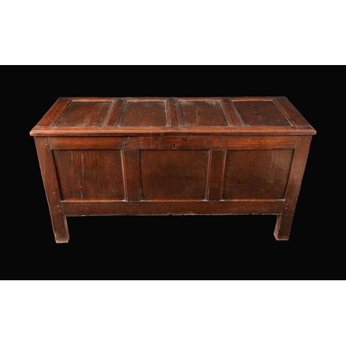 1577 - An early 18th century oak blanket chest, hinged four-panel top above a three-panel front, stile feet... 