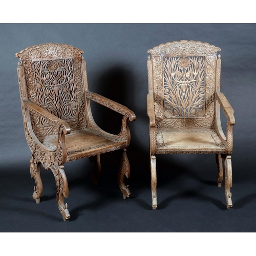 1583 - A pair of Anglo-Indian hardwood armchairs, shaped cresting, scroll arms, profusely carved with deer,... 