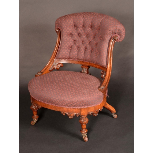 1591 - A Victorian walnut salon tub chair, button back, stuffed-over upholstery, turned legs carved with sc... 