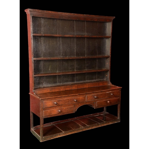 1594 - An 18th century oak dresser, outswept cornice above four shelves, the projecting base with an arrang... 