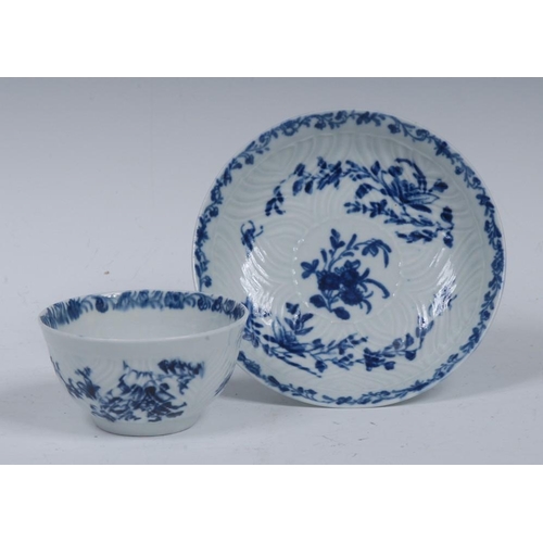 74 - A Worcester tea bowl and saucer, in relief with feathered mouldings, decorated in underglaze blue wi... 