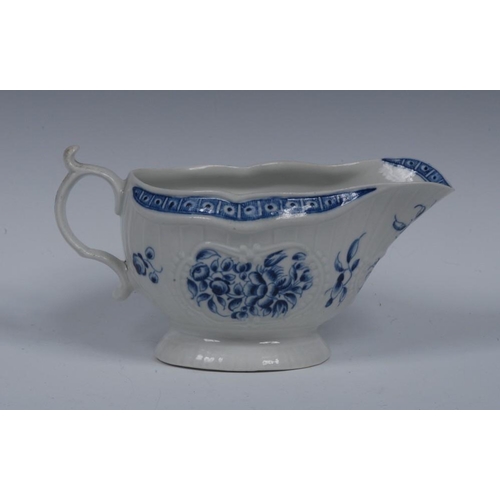 78 - A Worcester sauceboat, painted in underglaze blue with sprays of flowers, moulding with strap flutes... 