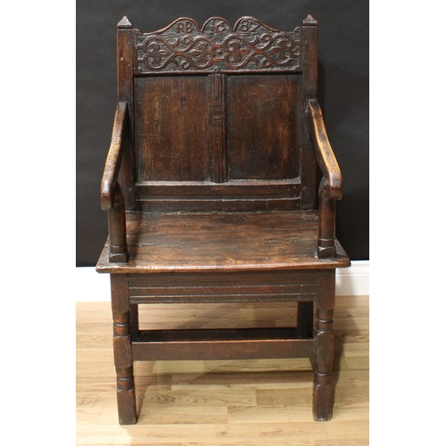 136 - A '17th century' oak Wainscote armchair, shaped cresting rail carved with strapwork and flanked by p... 