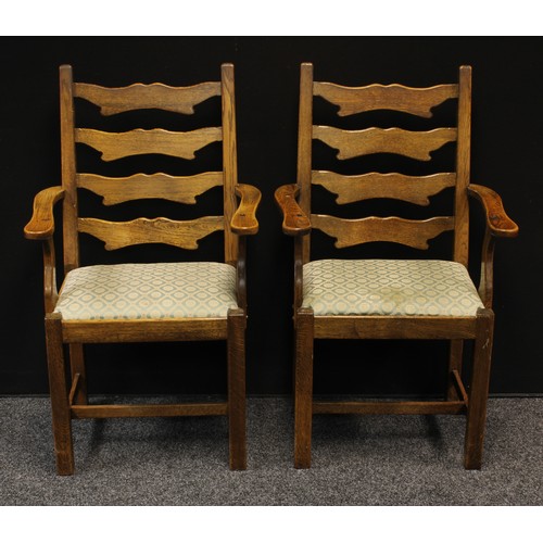 150 - A pair of 20th century oak open armchair/carvers. shaped ladder-backs, slightly outswept arms, drop-... 