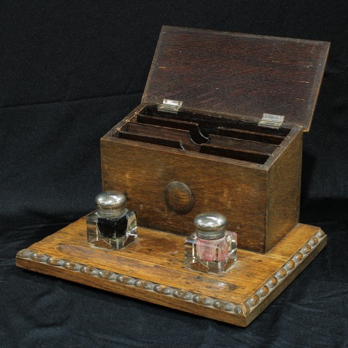 189 - An early 20th century oak combination stationery box and inkstand, in the Jacobean Revival taste, c.... 