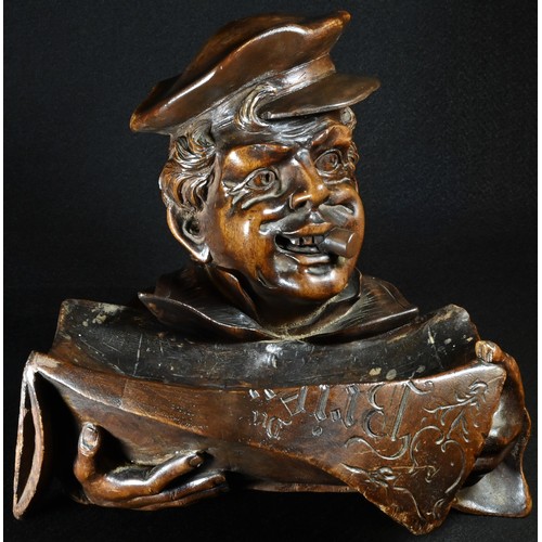 5068 - A Black Forest novelty desk tidy, carved as a newspaper vendor, wearing a cap and smoking a cigar, 2... 