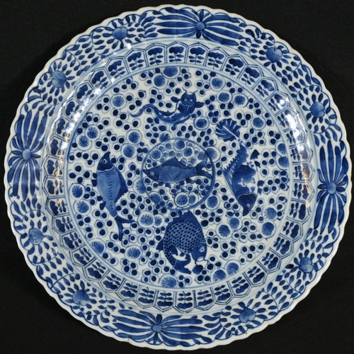 5099 - A Chinese shaped circular charger, painted in underglaze blue, the centre with five fish on a styliz... 