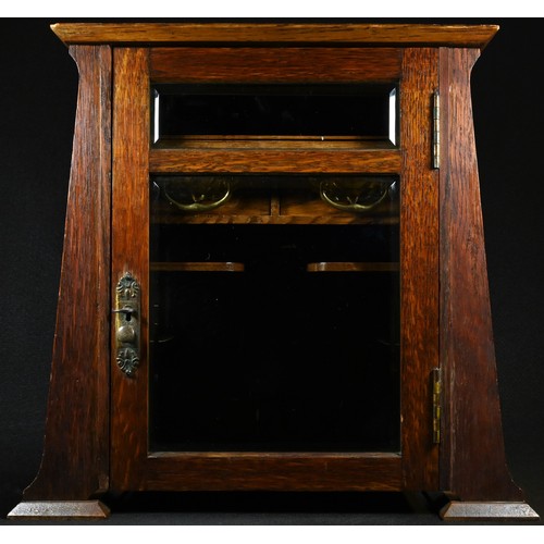 5272 - An Art Nouveau oak gentleman's smoking room cabinet, hinged cover and bevelled glazed door enclosing... 