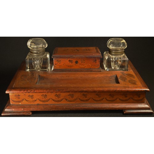 5310 - An Irish Arts and Crafts mahogany desk top inkstand, the central rectangular box flanked by a pair o... 