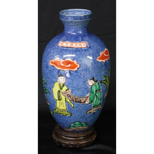 5095 - A Chinese ovoid vase, painted in polychrome with figures holding a scroll, beneath a banner inscribe... 