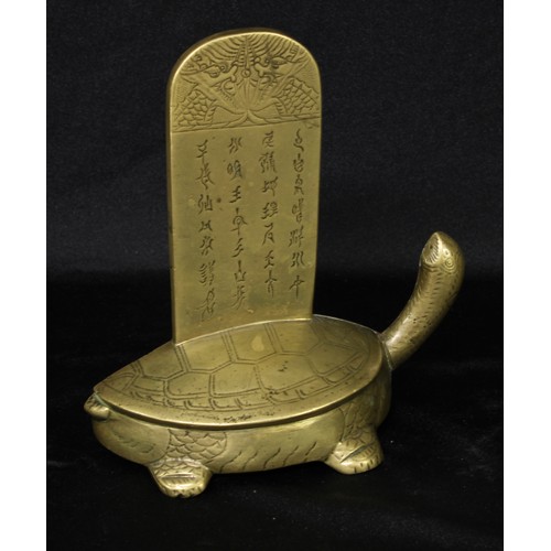 5080 - A Chinese bronze desk model, of a turtle supporting a tablet, engraved with dragons and inscribed wi... 