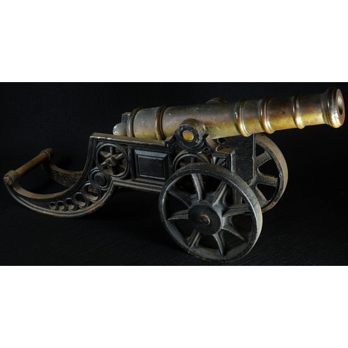 5074 - A bronze and cast iron model cannon, the carriage pierced with bands of fuilloche, spoked wheels, 45... 