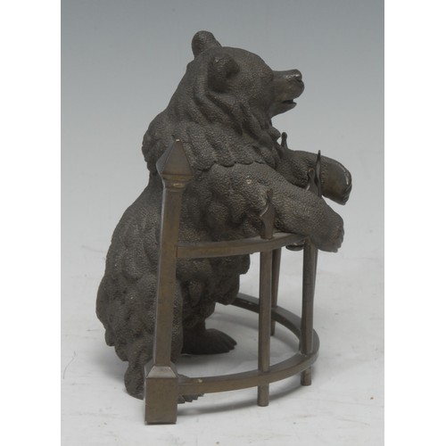 5059 - A 19th century Russian brown patinated bronze novelty inkwell, as a bear standing at railings, his h... 