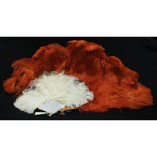 5313 - An orange ostrich feather fan, faux tortoiseshell sticks, 70cm long; another (2)