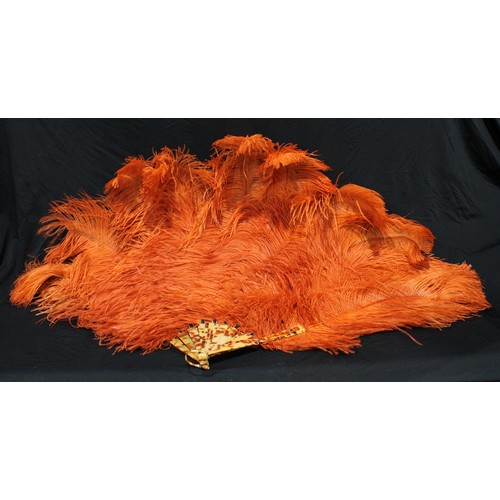 5313 - An orange ostrich feather fan, faux tortoiseshell sticks, 70cm long; another (2)