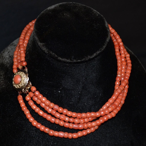 3053 - A four strand red coral bead necklace, four strands of irregular tubular ring beads, united by a cor... 