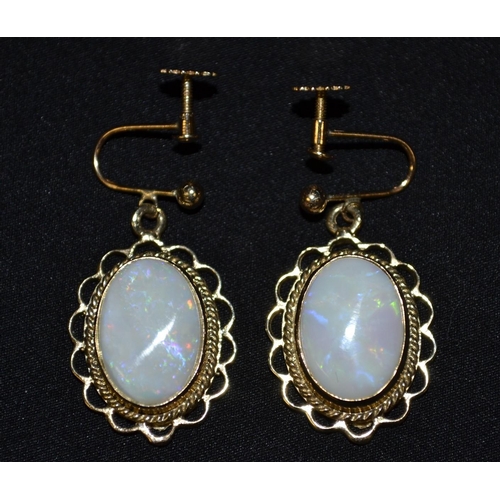 3056 - A pair of oval opal earrings, each drop earring set with a central oval opal, flashing blue, red,gre... 