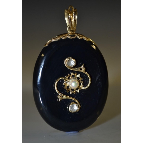 3059 - A large Victorian black onyx mourning locket, oval black onyx body mounted with a scrolling yellow m... 