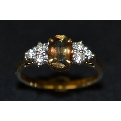 3060 - A diamond and citrine cluster ring, central oval champagne yellow citrine, flanked to each side by a... 