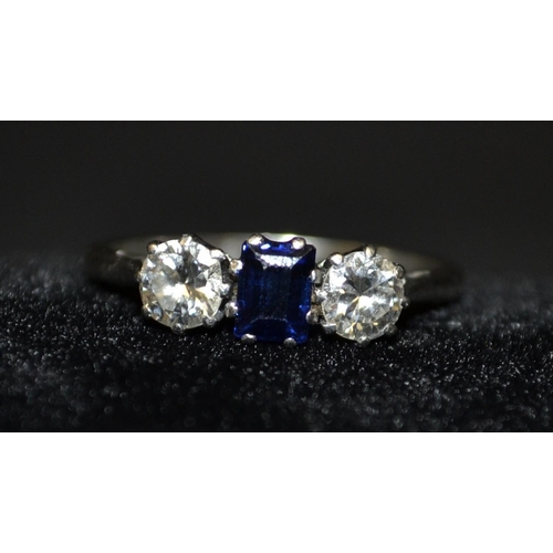 3112 - A diamond and sapphire trilogy ring, central blue rectangular baguette cur sapphire, flanked to each... 