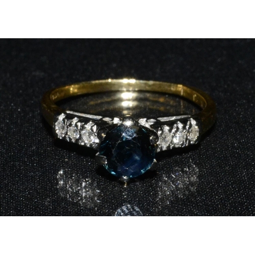 3119 - A sapphire and diamond ring, central pinnacle six claw set blue sapphire, flanked by diamond accent ... 