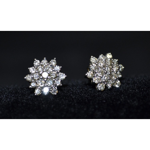 3120 - A pair of diamond snowflake cluster earring, each four level mount encrusted with nineteen round bri... 