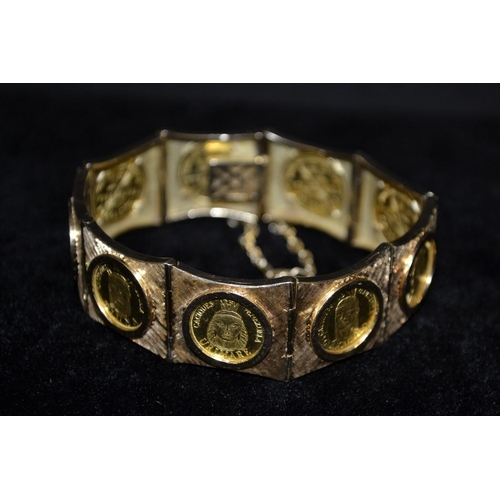 3130 - A Venezuelan coin bracelet, composed of nine individual hinged panels each set with a single Cacique... 