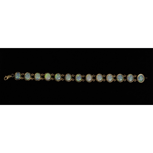 3182 - A thirteen panel opal bracelet, each oval opal flashing green, blue, orange, and red colour play, do... 