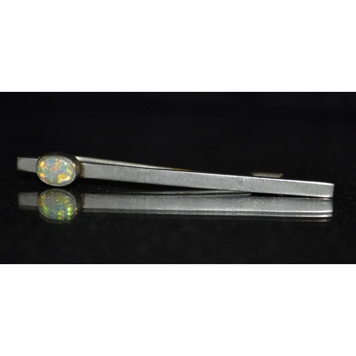 3152 - An early 20th century silver and opal tie pin, single oval opal flashing green, blue and orange colo... 