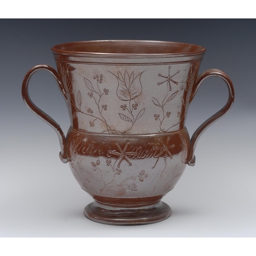 124 - An 18th century Nottingham brown salt glazed stoneware two-handled loving cup, of thistle form, inci... 