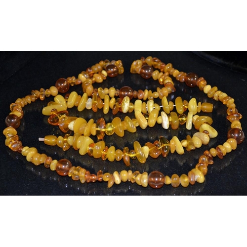 3163 - An irregular multi tone amber bead necklace, 73cm long;  another, barrel clasp, 48cm long, 105.2g gr... 