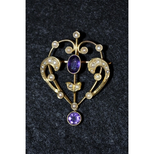 3417 - An Art Nouveau 9ct gold amethyst and seed pearl sweetheart brooch. open scrolling heart central set ... 