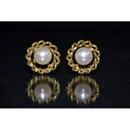 3439 - A pair of 18ct gold and pearl earrings, each with a central single cream cultured pearl, within a ch... 