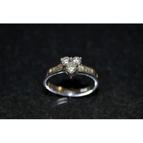 3440 - A diamond cluster ring, central triangular trilogy of round brilliant cut diamonds, above irregular ... 