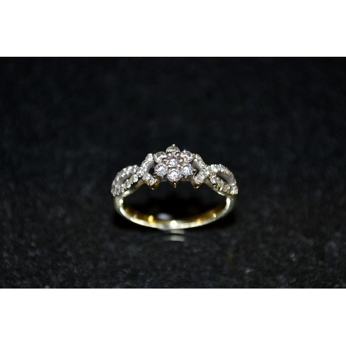 3445 - A Milabar diamond encrusted ring, central clusters of seven round cut diamonds, between open shoulde... 