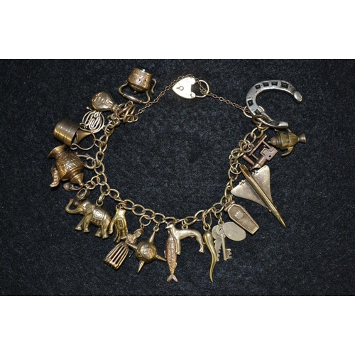 3447 - A 9ct gold charm bracelet, suspending nineteen gold, yellow and white metal charms including Concord... 