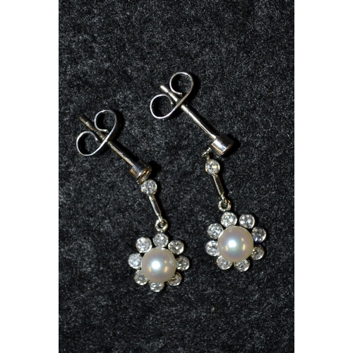 3465 - A pair of diamond and pearl flower head drop earrings, central creamy white pearl surrounded by a ba... 