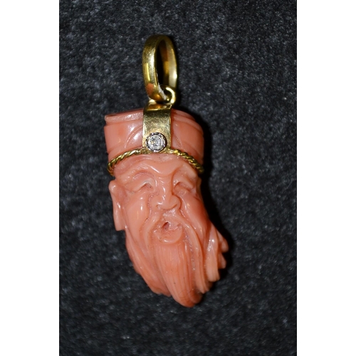 3469 - A carved coral pendant, Wise Elder Sage, with yellow metal crown, inset with a single round cut diam... 