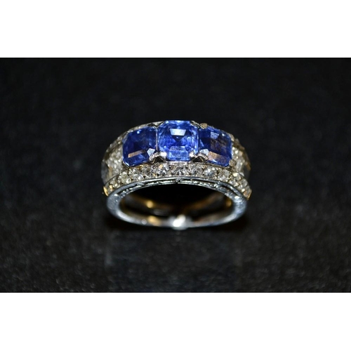 3477 - A sapphire and diamond ring, three rectangular baguette blue sapphires, above a pave diamond encrust... 