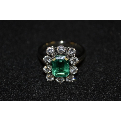 3490 - An emerald and diamond cluster ring, central rectangular cushion cut modified green emerald, approx ... 