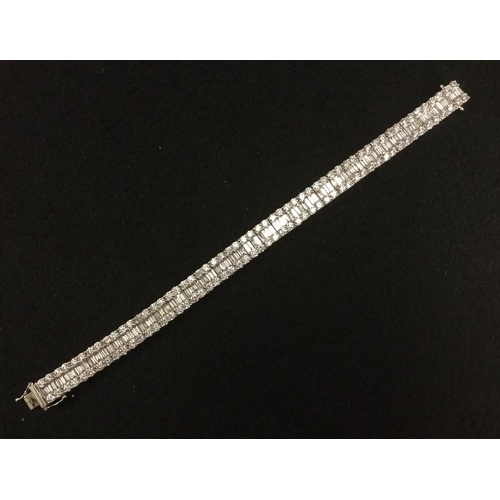 3495 - A diamond triple row tennis bracelet, central row of one hundred and twelve rectangular baguettes, f... 