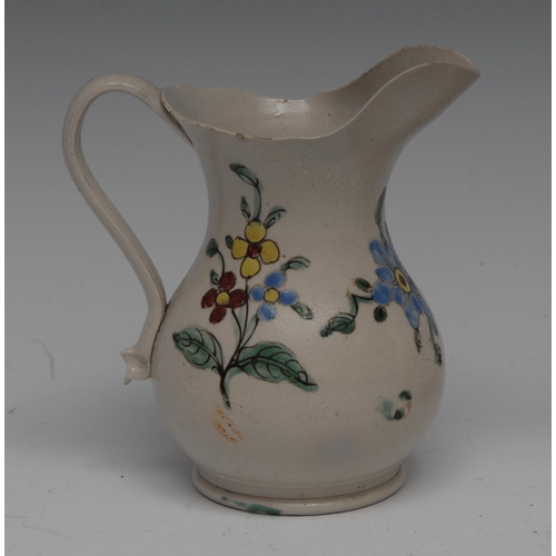 162 - An 18th century English saltglazed baluster cream jug, painted with large polychrome flowerhead and ... 