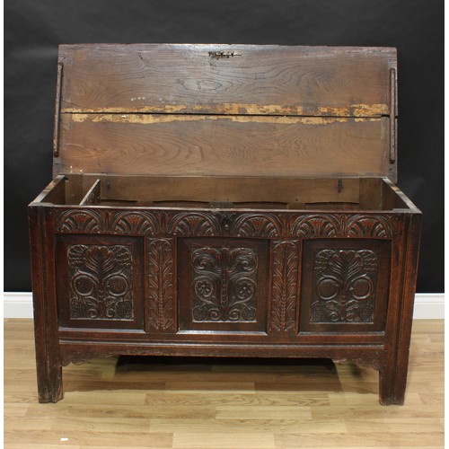 408 - An 18th century oak blanket chest, hinged top enclosing a till, the three panel front carved with le... 