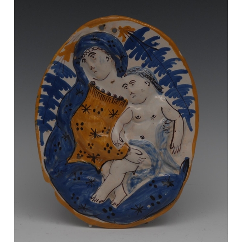 164 - An 18th century Delft oval plaque, in relief with Madonna and Child, in mustard and blue, 19cm high,... 