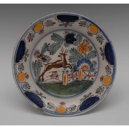 174 - A Dutch Delft circular plate, painted in polychrome with stag leaping, fence and stylised foliage, t... 