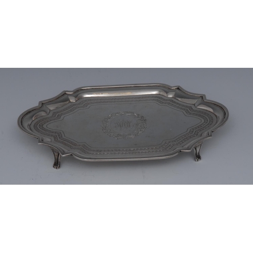 62 - A George III silver commode shaped teapot stand, bright-cut engraved and outlined with wrigglework, ... 