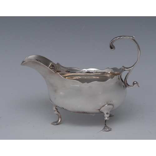 71 - A George III silver sauce boat, acanthus capped flying-scroll handle, wavy border, shaped pad feet, ... 