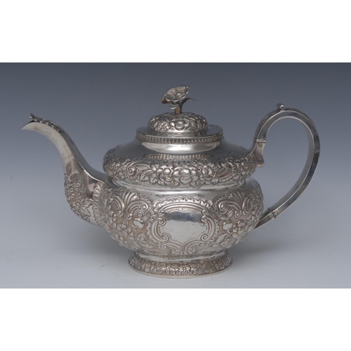 78 - A George IV Irish silver teapot, hinged cover with flower finial, chased with flowerheads, foliage a... 